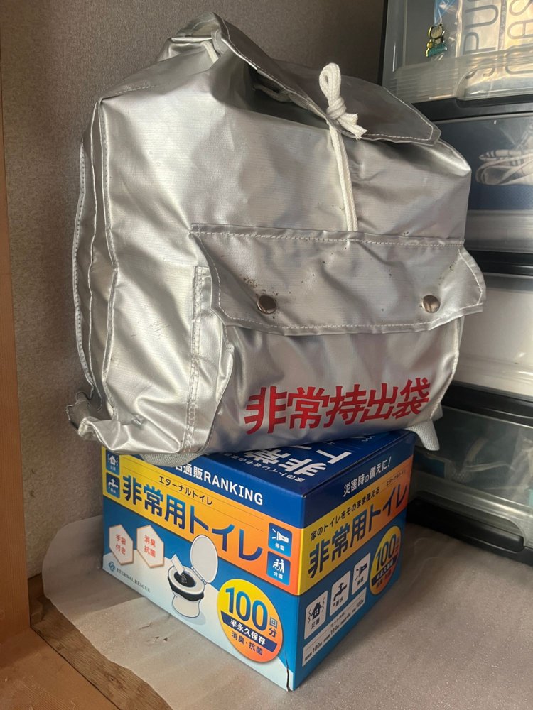 押し入れに置いた非常用トイレの箱と非常持出袋